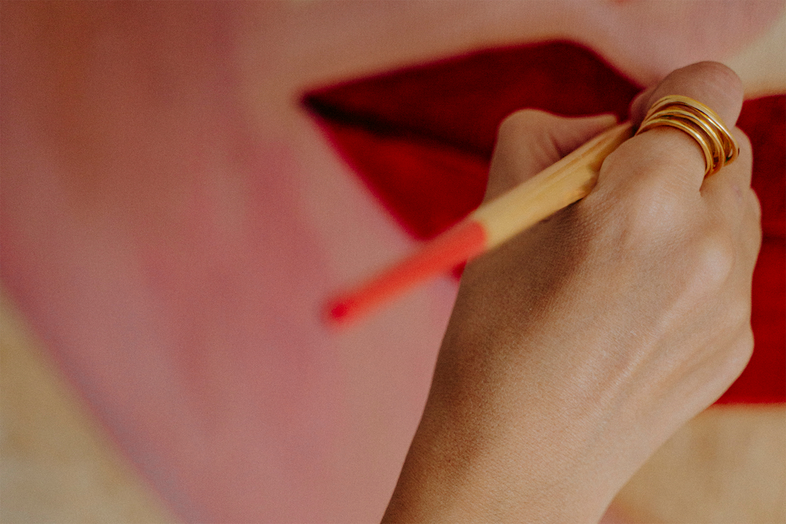 Zoom sur la main de Dalel qui peint un tableau